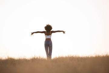 Image showing young black girl dances outdoors in a meadow