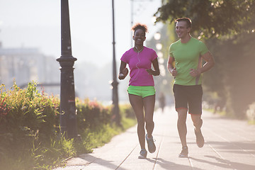 Image showing young multiethnic couple jogging in the city