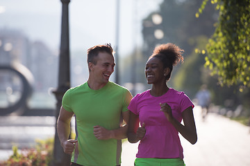 Image showing young multiethnic couple jogging in the city