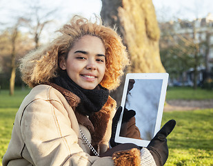 Image showing young cute blond african american girl student holding tablet and smiling, lifestyle people concept