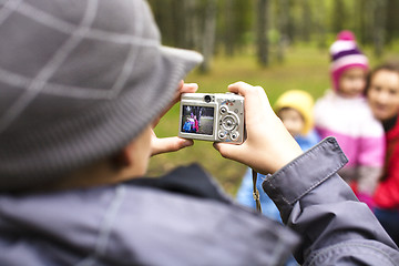 Image showing little offspring shooting his family in park outside, lifestyle people concept