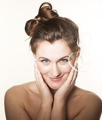 Image showing portrait of pretty young brunette woman on white background making bubbles happy smiling, lifestyle people concept