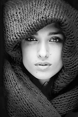 Image showing young pretty woman in sweater and scarf all over her face black and white