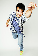 Image showing young pretty asian man jumping cheerful against white background, lifestyle people concept