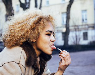 Image showing young pretty girl teenage outside smoking cigarette, looking like real junky, social issues conceptyoung pretty girl teenage outside smoking cigarette, looking like real junky, social issues concept