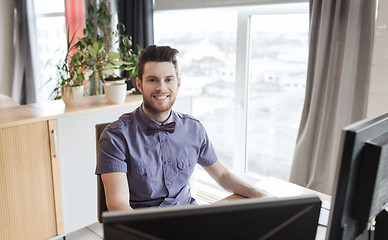 Image showing happy creative male office worker with computer