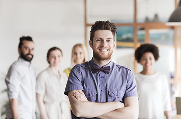 Image showing happy young man over creative team in office