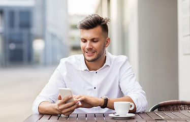 Image showing man with smartphone and coffee at city cafe