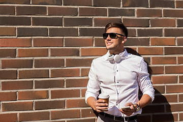 Image showing man with smartphone and coffee cup on city street