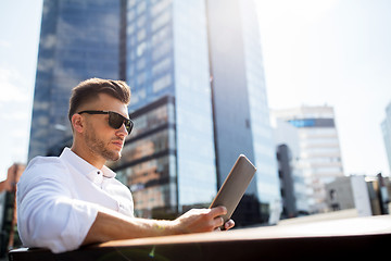 Image showing man with tablet pc sitting on city street bench