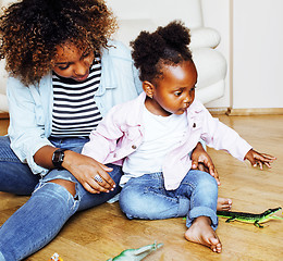 Image showing adorable sweet young afro-american mother with cute little daughter playing toys at home, lifestyle people concept