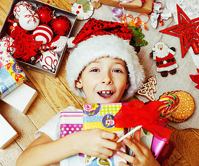 Image showing little cute boy with Christmas gifts at home. close up emotional