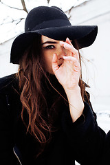 Image showing young pretty modern hipster girl waiting on bench at winter snow park alone, lifestyle people concept