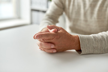 Image showing close up of senior man hands on table