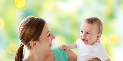 Image showing happy mother with little baby over green lights
