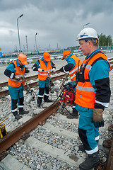 Image showing Railway workers repairing rail in rain