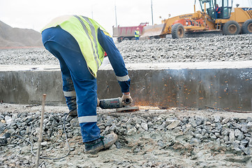 Image showing Worker cuts off surplus of fittings on new plant