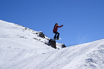 Image showing Snowboarder jumping in snow park at ski resort on sun winter day