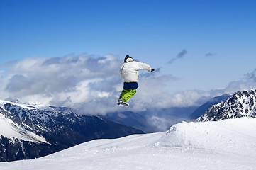 Image showing Snowboarder jumping in terrain park at ski resort on sun winter 