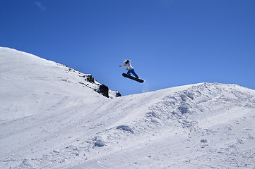 Image showing Snowboarder jumping in snow park at ski resort on sunny winter d