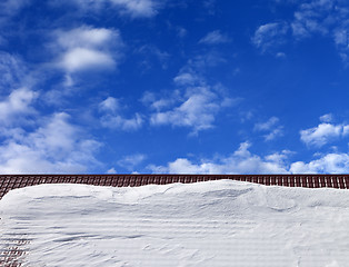 Image showing Roof in snow and blue sky with clouds