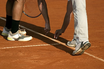 Image showing Tennis line referee and tennis player after serve