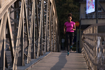 Image showing african american woman running across the bridge