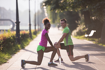 Image showing jogging couple warming up and stretching in the city