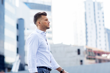 Image showing young man walking along city street