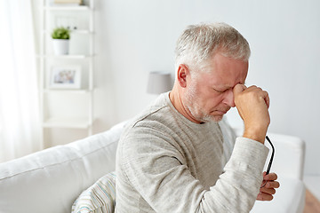 Image showing senior man suffering from headache at home