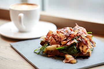 Image showing prosciutto ham salad on stone plate at restaurant