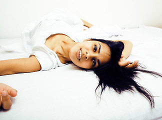 Image showing young pretty tann woman in bed among white sheets having fun, tr