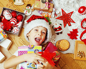 Image showing little cute boy with Christmas gifts at home. close up emotional