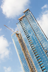 Image showing Skyscrappers construction site with cranes on top of buildings.