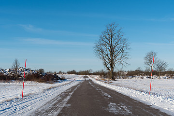 Image showing Snowy country road with snow stakes