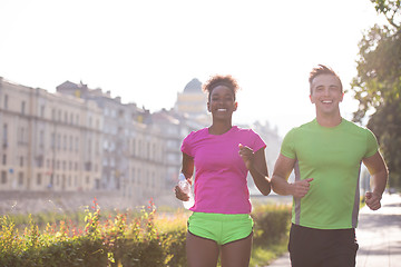 Image showing young multiethnic couple jogging in the city