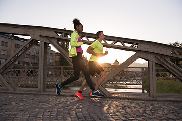 Image showing young multiethnic couple jogging in the city