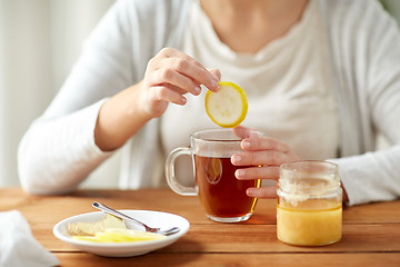 Image showing close up of ill woman drinking tea with lemon