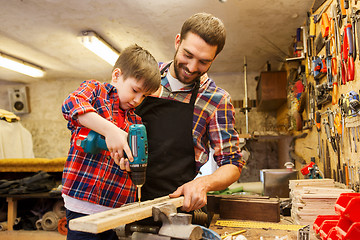 Image showing father and son with drill working at workshop