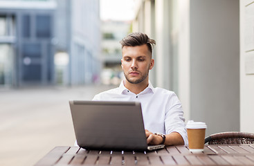 Image showing man with laptop and coffee at city cafe