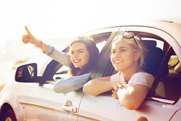 Image showing happy teenage girls or women in car at seaside