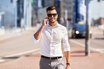 Image showing happy man with smartphone calling on city street