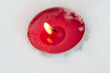 Image showing burning christmas candle on snow in winter