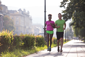 Image showing young multiethnic couple jogging in the city