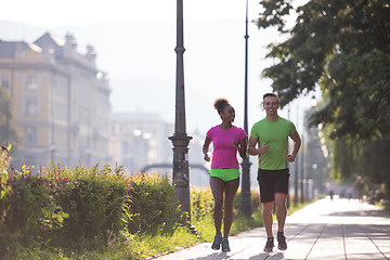 Image showing young multiethnic couple jogging in the city