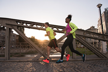 Image showing young multiethnic couple jogging in the city