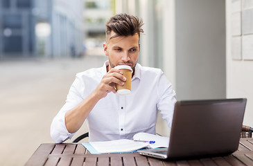 Image showing man with laptop and coffee at city cafe