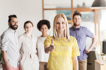 Image showing woman showing thumbs up over creative office team