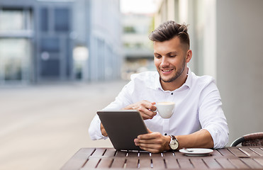 Image showing man with tablet pc and coffee at city cafe