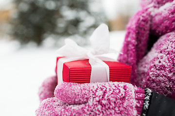 Image showing close up of woman holding christmas gift outdoors